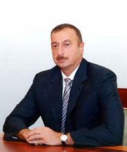 Politisches System in Azerbajan. Der Präsident İlham Əliyev bzw. sein Vater und Nationalflagge sind überall präsent.